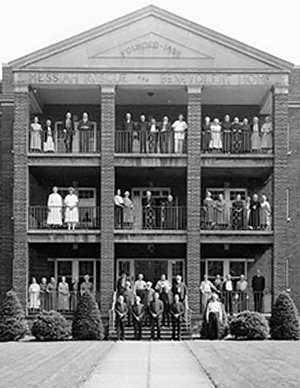 a group of people standing in front of a building that says founded 1896