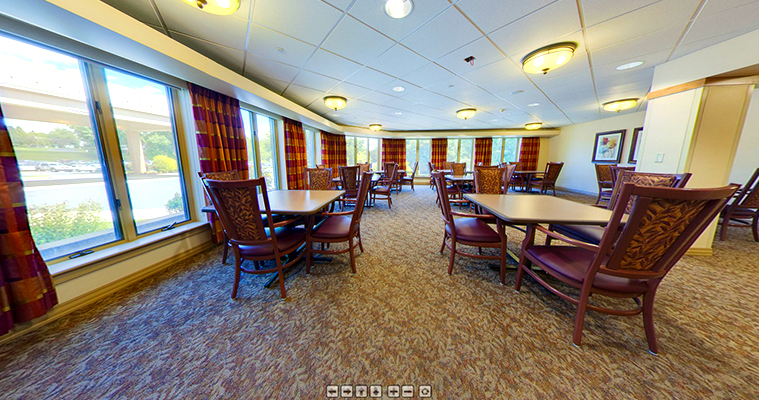 a dining room with tables and chairs and large windows