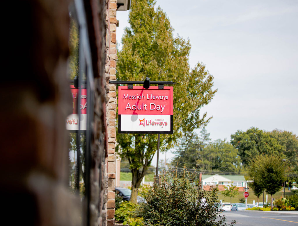 a red sign that says messiah lifeways adult day