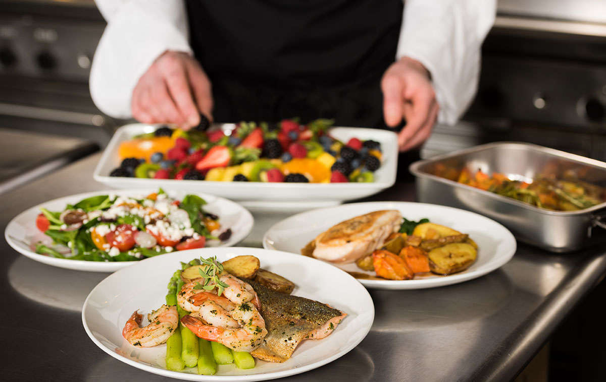 a chef is preparing plates of food in a kitchen