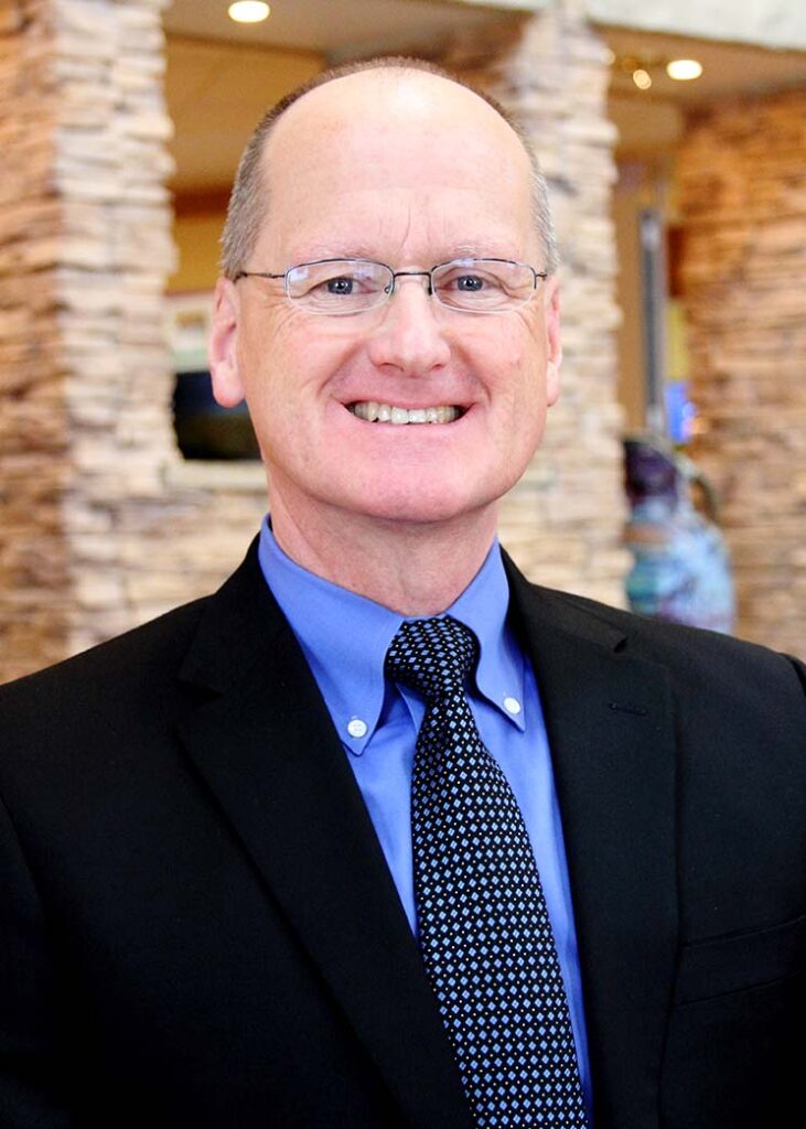 a man in a suit and tie smiles for the camera