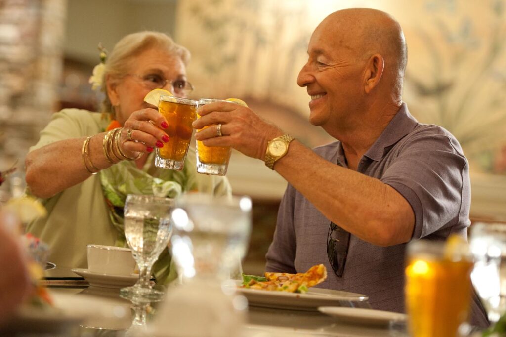 a man and a woman are toasting with glasses of iced tea