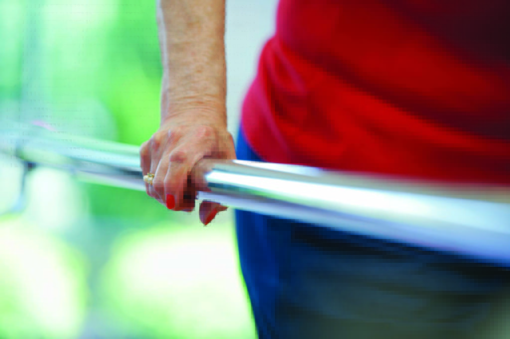 a woman in a red shirt is holding onto a railing