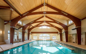 a large indoor swimming pool with a wooden ceiling