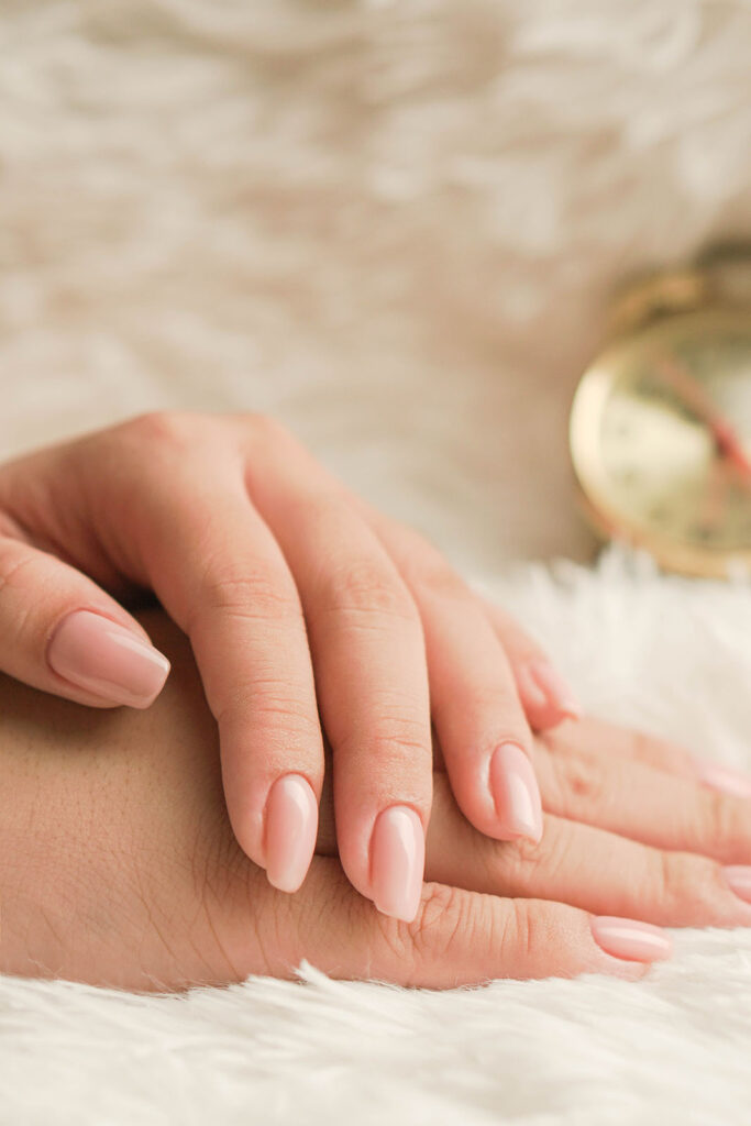a close up of a woman's hand with pink nails