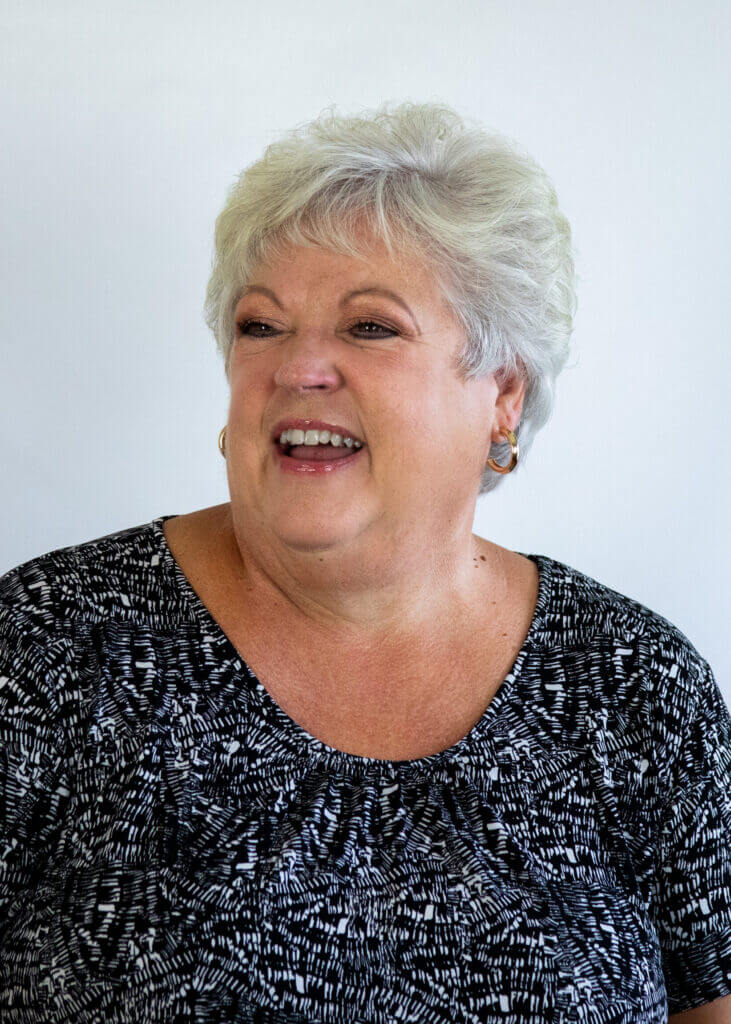 a woman wearing a black and white shirt is smiling